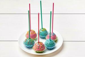 Cake pops in pink and blue glaze with colorful sprinkles photo