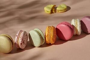 Whole macarons arranged in line and one broken cookie photo
