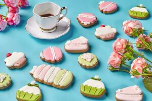 Gingerbread cookies with sugar icing, cup of coffee and roses photo