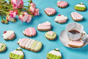 Gingerbread cookies with sugar icing, cup of coffee and roses photo