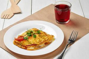 French omelet with cheese and vegetables with berry juice photo