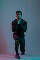 Sporty young man doing forward lunges with dumbbell photo