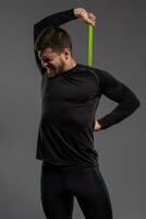 Man with tense facial expression performing resistance band workout photo