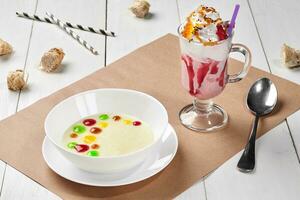 Sweet semolina porridge with fruit toppings and berry milkshake photo