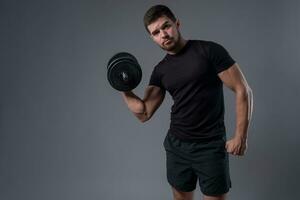 Young man doing set of arm exercises with dumbbells photo