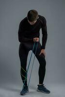 Young man doing biceps workout with resistance band photo