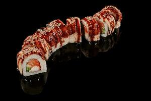 Sushi rolls with eel, shrimp, salmon, tobiko, cucumbers and unagi sauce photo