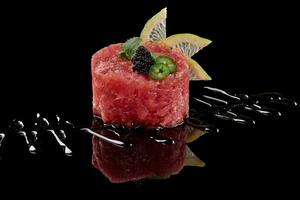Raw tuna tartare with tobiko, lime, greens and soy sauce photo