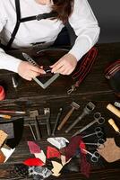 Woman artisan making genuine leather handle for new handbag photo