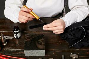 Female artisan making genuine leather handbag at table photo