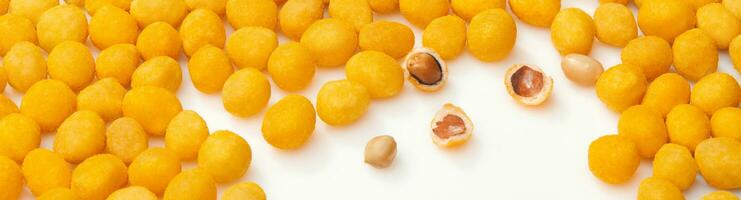 Yellow salty roasted peanuts with bacon flavor on white surface photo