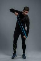Athletic young man working out with resistance loop band photo