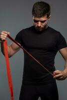 Young muscular man with boxing tape on grey background photo