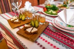 Salted pork fatback with rye bread, pickles and medovukha on table photo