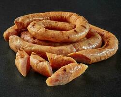 Slices of lightly smoked poultry sausages in natural casings photo