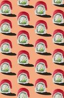 Pattern of Philadelphia rolls with tuna on pinkish orange background photo