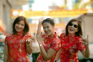 Grupo de mujer asiática vistiendo ropa de tradición china con dientes cara sonriente felicidad emoción y signo de mano te amo foto