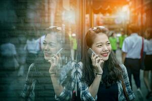 portrait of younger asian woman talking to smart phone toothy smiling face with  happiness emotion photo