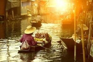 tailandés Fruta vendedor navegación de madera barco en Tailandia tradicion flotante mercado foto