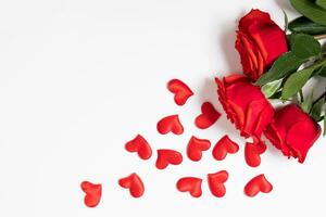 rojo rosas y corazones en un blanco antecedentes. San Valentín día saludo tarjeta. sitio para tu texto. foto