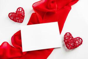 Red hearts and silk ribbon on a white background photo