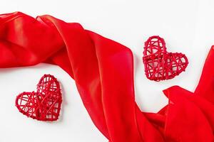 Red hearts and silk ribbon on a white background photo