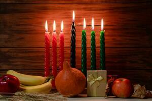 Happy Kwanzaa. Seven candles red, black and green on wooden background. photo