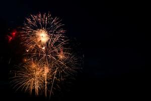fuegos artificiales de colores sobre fondo negro. concepto de celebración y vacaciones. día de la independencia 4 de julio, año nuevo, festival. brillantes explosiones de luces en el cielo. foto