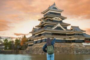 Woman tourist Visiting in Matsumoto, happy Traveler sightseeing Matsumoto Castle or Crow castle. Landmark and popular for tourists attraction in Matsumoto, Nagano, Japan. Travel and Vacation concept photo