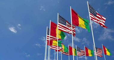 United States and Guinea Flags Waving Together in the Sky, Seamless Loop in Wind, Space on Left Side for Design or Information, 3D Rendering video