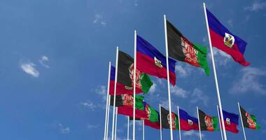 afghanistan e Haiti bandiere agitando insieme nel il cielo, senza soluzione di continuità ciclo continuo nel vento, spazio su sinistra lato per design o informazione, 3d interpretazione video