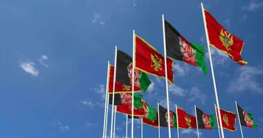 Afghanistan and Montenegro Flags Waving Together in the Sky, Seamless Loop in Wind, Space on Left Side for Design or Information, 3D Rendering video