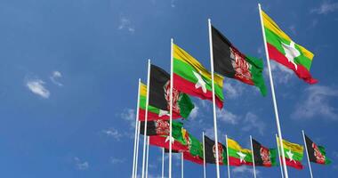Afganistán y myanmar, birmania banderas ondulación juntos en el cielo, sin costura lazo en viento, espacio en izquierda lado para diseño o información, 3d representación video