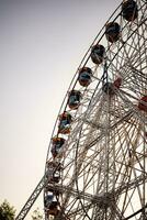 New Delhi, India - October 30 2023 - Closeup of multi-coloured Giant Wheel during Dussehra Mela in Delhi, India. Bottom view of Giant Wheel swing. Ferriswheel with colourful cabins during day time. photo