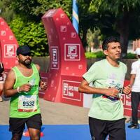 New Delhi, India - October 15 2023 - Vedanta Delhi Half Marathon race after covid in which marathon participants about to cross the finish line, Delhi Half Marathon 2023 photo