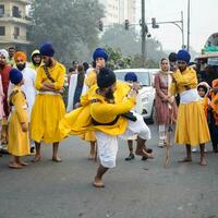 Delhi, India, October 2, 2023 - Sikhs display gatka and martial arts during annual Nagar Kirtan, Traditional, procession on account of birthday of Guru Nanak Dev ji, Nagar Kirtan in East Delhi area photo