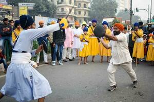 Delhi, India, October 2, 2023 - Sikhs display gatka and martial arts during annual Nagar Kirtan, Traditional, procession on account of birthday of Guru Nanak Dev ji, Nagar Kirtan in East Delhi area photo