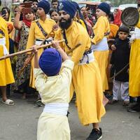 Delhi, India, October 2, 2023 - Sikhs display gatka and martial arts during annual Nagar Kirtan, Traditional, procession on account of birthday of Guru Nanak Dev ji, Nagar Kirtan in East Delhi area photo