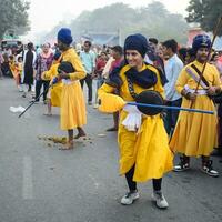 Delhi, India, October 2, 2023 - Sikhs display gatka and martial arts during annual Nagar Kirtan, Traditional, procession on account of birthday of Guru Nanak Dev ji, Nagar Kirtan in East Delhi area photo