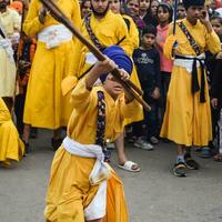 Delhi, India, October 2, 2023 - Sikhs display gatka and martial arts during annual Nagar Kirtan, Traditional, procession on account of birthday of Guru Nanak Dev ji, Nagar Kirtan in East Delhi area photo