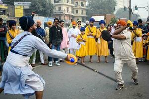 Delhi, India, October 2, 2023 - Sikhs display gatka and martial arts during annual Nagar Kirtan, Traditional, procession on account of birthday of Guru Nanak Dev ji, Nagar Kirtan in East Delhi area photo