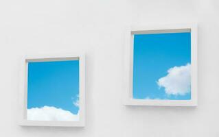 White Wall texture of concrete with open window against blue sky and clouds inSummer, Exterior Cement building with two border frame with Spring sky,Ant view Modern architecture. Minimal design photo
