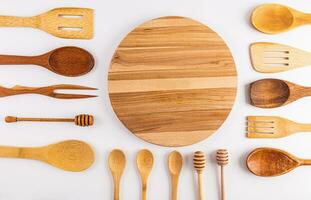 Beautiful kitchen background with wooden tool on a white table with a round cutting board in the center. Flat lay. Top view. space for text. photo