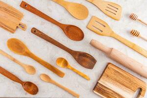 Beautiful stylish kitchen background with wooden spoons, forks, spatula on light stone countertop. Top view. Flat layout. Eco items. photo