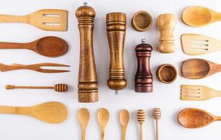 Various kitchen utensils made of natural materials on a light background. Flat laying. Top view. Eco items. photo