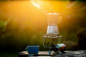 Moka pot and smoke, Steam from the coffee pot on fire, In the forest at sunrise in the morning. soft focus. shallow focus effect. photo