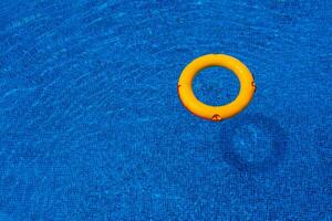 Top view of lifebuoy floating in blue swimming pool, soft focus. photo