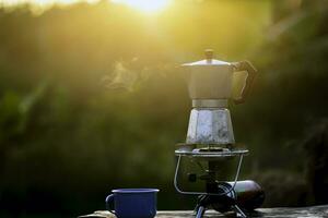 Moka pot and smoke, Steam from the coffee pot on fire, In the forest at sunrise in the morning. soft focus. shallow focus effect. photo