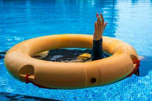 Top view of lifebuoy floating in blue swimming pool, soft focus. photo