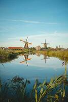 Popular tourist spot Zaanse Schans is near Amsterdam in the west of the Netherlands. Historical, realistic windmills during sunrise. Holland's landmark photo